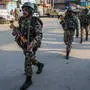 Indische Soldaten patrouillieren durch die Straßen einer Stadt in Kaschmir