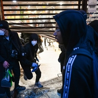 Plünderer tragen ihre Beute aus einem Geschäft in Paris.