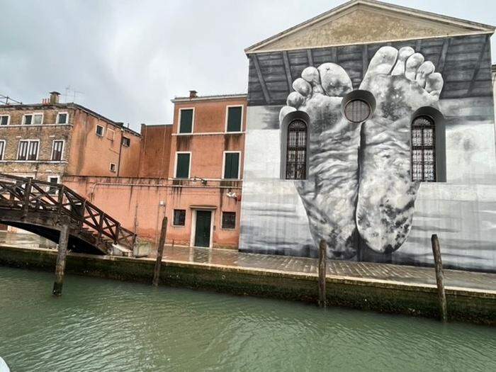 Das Frauengefängnis am Kanal mit dem Kunstwerk von Maurizio Cattellan, die Sohlen zweier bloßer Füße in schwarzweiß zeigt.  | Das Frauengefängnis mit dem Kunstwerk von Maurizio Cattellan 