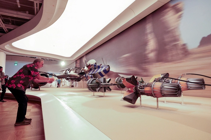 Ein Besucher macht ein Foto von Anakin Skywalkers Podracer aus dem Film Episode I – Die dunkle Bedrohung