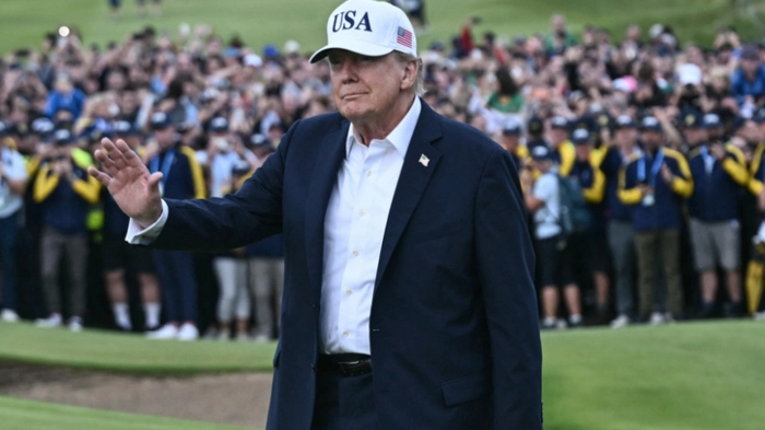 US President Donald Trump waves before presenting the winner's trophy to Ireland's Shane Lowry (not pictured) following his victory on the final day of the Irish Open golf tournament at the Trump International Golf Links &amp; Hotel, a resort and golf course owned by the president, in Doonbeg, western Ireland on September 13, 2026. (Photo by Brendan SMIALOWSKI / AFP)