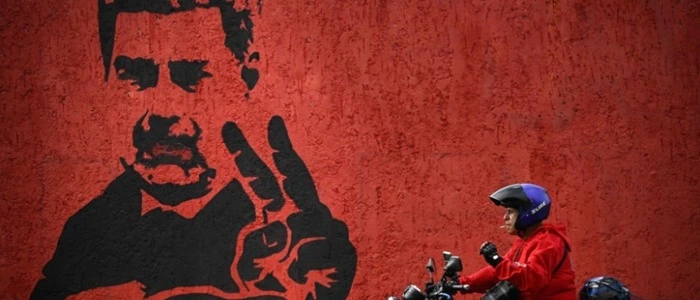 (FILES) A motorcyclist rides past a mural of ousted Venezuela's President Nicolas Maduro flashing the V sign, in Caracas, on May 14, 2026. Eight months after US forces captured Venezuelan President Nicolas Maduro on January 3, 2026, the prevailing national mood is bittersweet as delight at his fall gives way to impatience about ongoing economic hardship. (Photo by Federico PARRA / AFP)