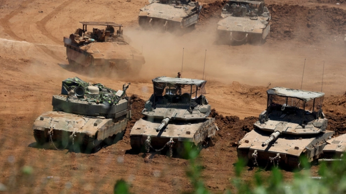 This picture taken from a position in the Upper Galilee in northern Israel shows Israeli army tanks positioned along the Israel-Lebanon border, on July 1, 2026. Israel's defence minister said on July 1 that Israeli forces would remain in self-proclaimed "security zones" established in Lebanon, Syria and Gaza, without any timeline for withdrawal. (Photo by Jack GUEZ / AFP) /