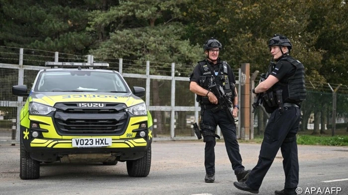 Armed police stand guard at an entrance to RAF Fairford base in Fairford, south-west England on September 27, 2026, as UK counter-terrorism police investigate an incident near the base in the village of Whelford. British police on September 27 declared a major incident and evacuated villagers living near a base used by the US air force after arresting several men on suspicion of explosives offences. (Photo by JUSTIN TALLIS / AFP)