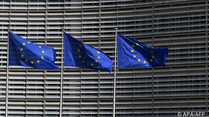 This photograph shows European Union flags outside the EU Commission headquarters in Brussels on March 16, 2026. (Photo by Nicolas TUCAT / AFP)