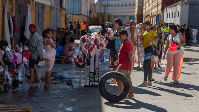 Migrants wait to receive drinking water in the Spanish North African enclave of Ceuta on August 7, 2026, following a mass influx of migrants from Morocco in recent days. Of the 72,000 migrants who reached Ceuta, 70,000 have returned to Morocco, according to official Spanish figures, which have recorded 80 deaths. Morocco's interior ministry has said 11 people died on the Moroccan side of the border, all but one by drowning. Those who remain in Ceuta -- including hundreds of unaccompanied children -- face dire living conditions with little access to food, water, shelter and sanitation. (Photo by Antonio Sempere / AFP)