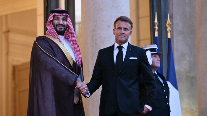 France's President Emmanuel Macron (R) welcomes Saudi Arabia's Crown Prince Mohammed bin Salman as he arrives for a State diner in his honour at the Elysee Palace in Paris on August 24, 2026. (Photo by LOU BENOIST / AFP)