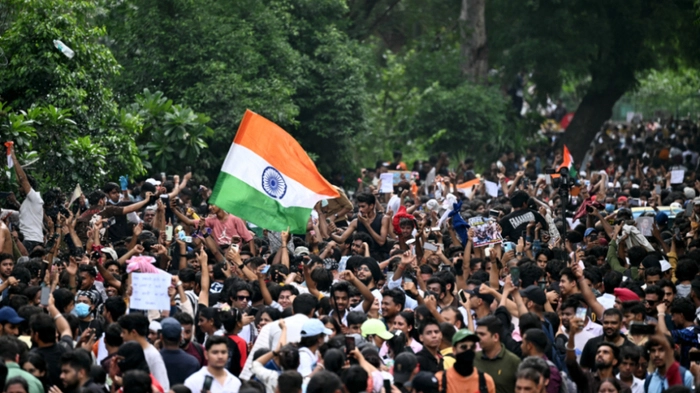 Cockroach Janta Party (CJP) supporters celebrate the resignation of India's Education Minister Dharmendra Pradhan, at Jantar Mantar in New Delhi on July 25, 2026 amid the ongoing protests over alleged NEET exam irregularities. India's education minister Dharmendra Pradhan on July 25 sent his resignation to Prime Minister Narendra Modi after the youth-led Cockroach Janta Party online movement weeks-long protest over irregularities in the education department. (Photo by Sajjad HUSSAIN / AFP)
