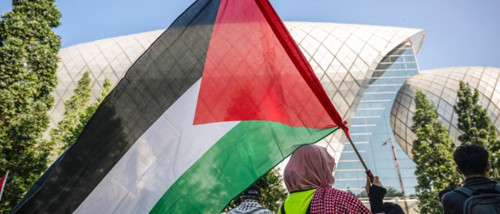 A protester carries a Palestinian flag during a rally condemning US-Israeli attacks on Iran and Israeli attacks on Lebanon and Palestine on the sidelines of the Defence Services Asia (DSA) Exhibition and Conference outside the Malaysia International Trade and Exhibition Centre (MITEC) in Kuala Lumpur on April 20, 2026. (Photo by Mohd Rasfan / AFP)