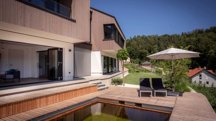 Der untere Wohnbereich mit gemütlicher Lounge und Zugang zum Naturpool 
