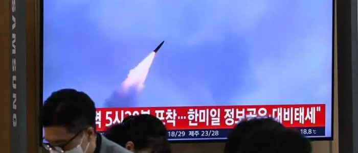 People sit near a television screen showing a news broadcast with file footage of a North Korean missile test, at a train station in Seoul on September 12, 2026. North Korea fired an unidentified projectile toward the Sea of Japan on September 12, South Korea's defence ministry said. (Photo by Jung Yeon-je / AFP)