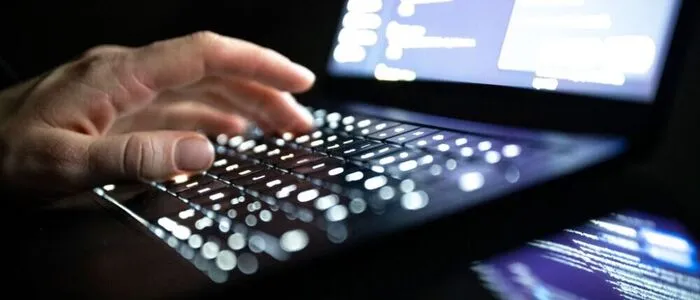Eine Hand tippt auf einer Laptop-Tastatur