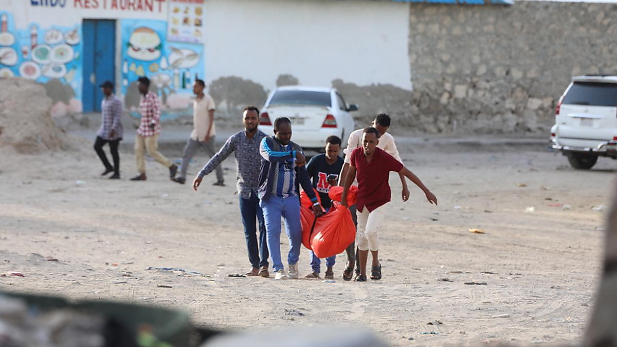 Verwandte bringen ein weibliches Terroropfer weg vom Strand