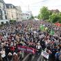 Teilnehmer einer Kundgebung stehen auf dem Dresdner Pohlandplatz