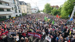 Teilnehmer einer Kundgebung stehen auf dem Dresdner Pohlandplatz