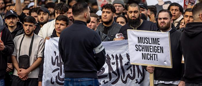Teilnehmer einer Islamisten-Demo halten ein Plakat mit der Aufschrift „Muslime schweigen nicht“ in die Höhe | Teilnehmer einer Islamisten-Demo halten ein Plakat mit der Aufschrift „Muslime schweigen nicht“ in die Höhe