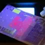 Mittels UV-Licht werden Euro-Noten auf Echtheit geprüft | Mittels UV-Licht werden Euro-Noten auf Echtheit geprüft