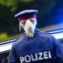 Polizistin vor Polizeiauto mit Blaulicht