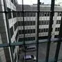 Blick durch Gitterstäbe in einen Innenhof.