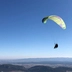 Das Bild zeigt einen Paragleiter am Himmel. 
