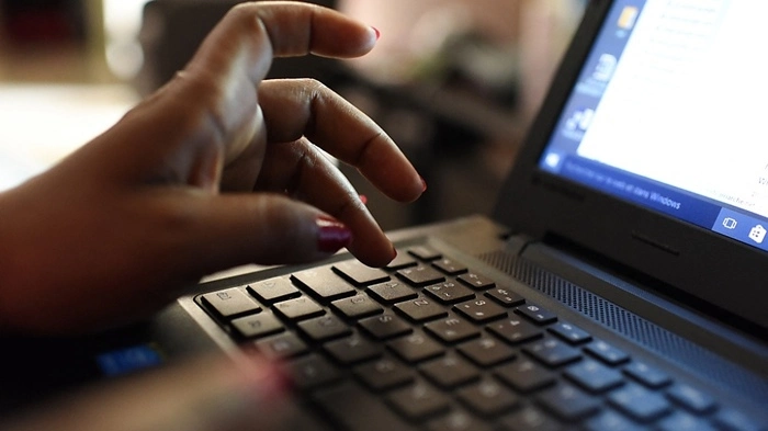 Finger einer Frau auf der Tastatur eines Laptops