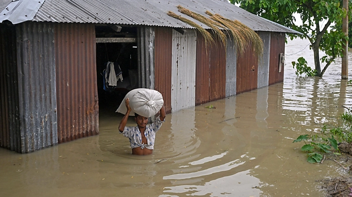 Mann mit Reissack in überfluteter Gegend in Assam | Mann mit Reissack in überfluteter Gegend in Assam