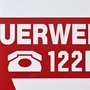 In großen Buchstaben ist auf dem Bild das Wort Feuerwehr und die Notrufnummer 122 zu lesen