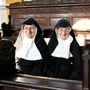 Die drei Nonnen von Goldenstein sitzen auf einer Kirchenbank