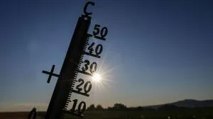 Auf dem Foto ist ein Thermometer zu sehen, im Hintergrund scheint die Sonne