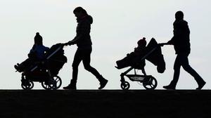 Zwei Kinderwägen, die auf einer Straße geschoben werden. | Kinderarmut ist teuer. Laut OECD kosten deren Folgen Österreich 17 Milliarden Euro pro Jahr.