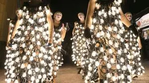 In Lichter gewickelte Personen laufen durch eine Straße