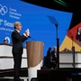 IOC-Präsident Bach hält den Entschluss hoch | IOC-Präsident Bach hält den Entschluss hoch