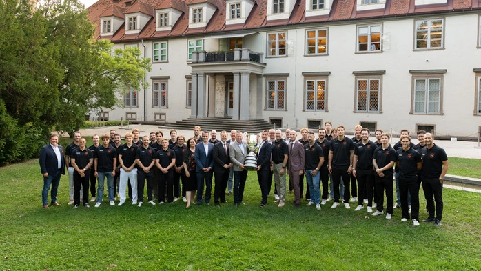 Gruppenbild mit Pokal: die 99ers im Burggarten mit LH Mario Kunasek, Landesräten und dem Meisterpokal 