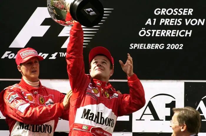 Symbolisch überreichte Schumacher seinem Teamkollegen Barrichello 2002 die Siegertrophäe