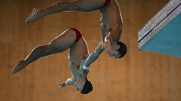 Austria's diver Anton Knoll qnd Austria's diver Dariush Lotfi compete in the men’s 10m platform synchro diving final event during the LEN European Aquatics Championships, at the Olympic Aquatics Centre in Saint-Denis, northeastern suburbs of Paris, on August 4, 2026. (Photo by SEBASTIEN BOZON / AFP)