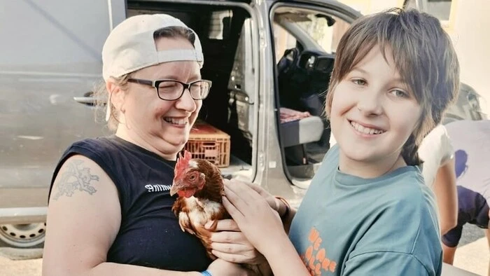 Tierschützerin Angelika Höller-Schmitt und der zwölfjährige Jakob Jungwirth aus Graz mit einer der vermittelten Legehennen