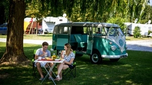 Ein Pärchen sitzt auf einem Tisch vor einem Campingwagen