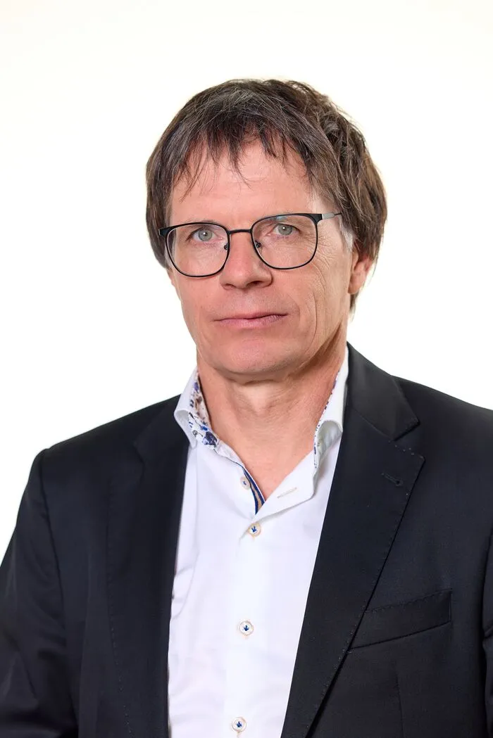 Porträtfoto von Robatsch, er trägt Brille und einen dunklen Blazer