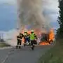 Feuerwehrleute löschen brennendes Fahrzeug