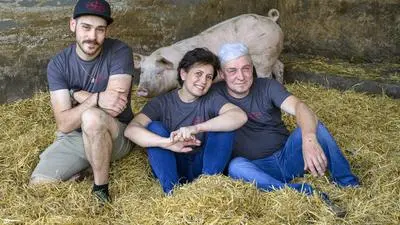 Philipp, Daniele und Helmut Augustin aus Unterauersbach in ihrem Schweinestall