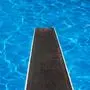 Swimming pool with diving board and reflections