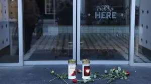 Grabkerzen und Blumen vor der geschlossenen Filiale in der Grazer Kaiserfeldgasse