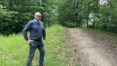 Stadtförster Peter Bedenk im Leechwald vor einem Hügelgrab aus der Römerzeit, das Mountainbiker als Hindernis nutzen 