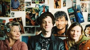 Ein Foto der drei Personen, im Hintergrund die Wand eines alten Jugendzimmers, mit vielen Postern von Schauspieler Patrick Swazye