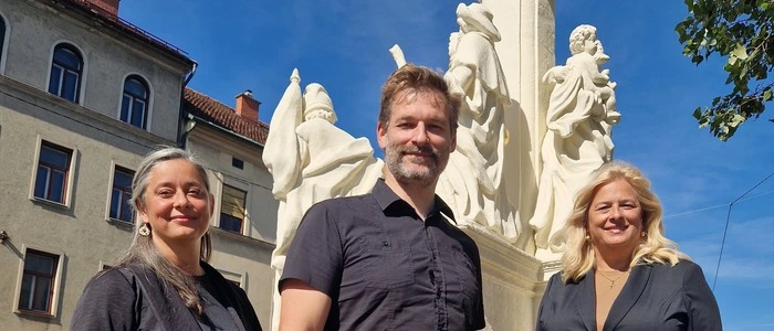 Stadträtin Claudia Unger (rechts) mit den Restauratoren Jenny Pfeifruck-Vass und Mario Ruml vor der sanierten Mariensäule