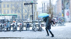 Schneechaos in Graz: Person schützt sich mit Schirm vor den Schneefällen