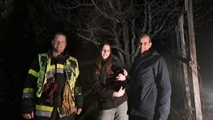 Die zwei Besitzer mit ihrer schwarzen Katze, daneben einer der Feuerwehrmänner