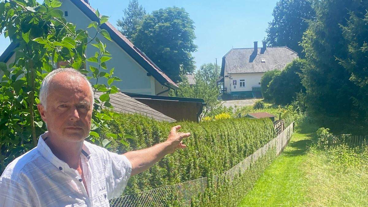 Anrainer Thomas Dobrovnik zeigt auf das alte Gasthaus und den schmalen Feldweg