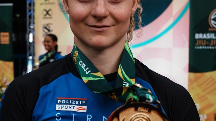 Inga Boruch hält eine Medaille in die Kamera.