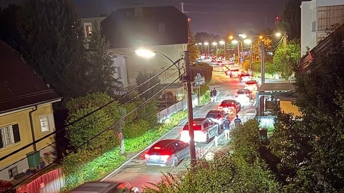 Eine lange Schlange Autos staut abends am Neufeldweg